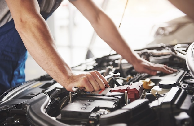 Meccanico auto che lavora in garage. Servizio di riparazione.