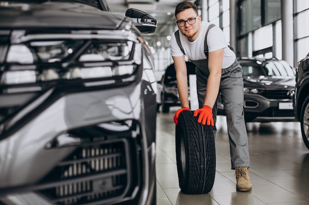 Meccanico che cambia le gomme in un servizio di auto