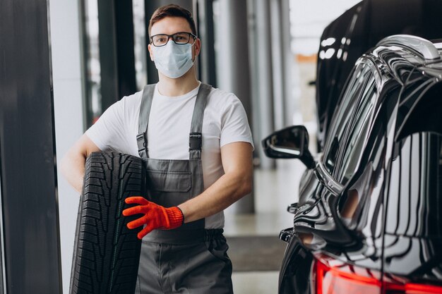 Meccanico che cambia le gomme in un servizio di auto