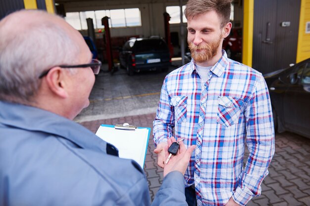 Meccanico che consegna le chiavi dell'auto a un cliente