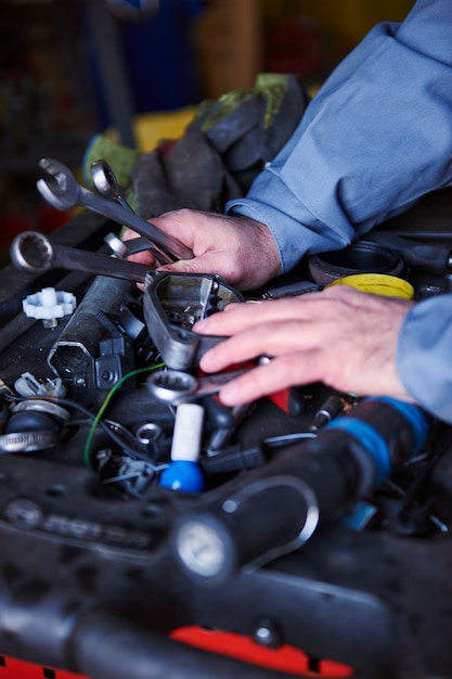 Meccanico che ripara un'auto in officina