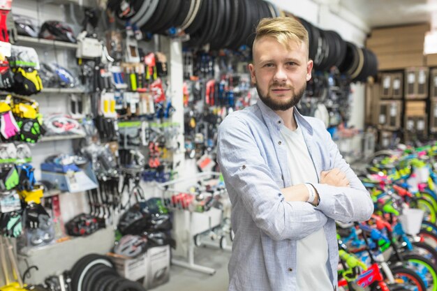 Meccanico con le braccia piegate che stanno nell&#39;officina della bicicletta