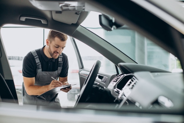 Meccanico d'auto che controlla un'auto in un servizio di auto