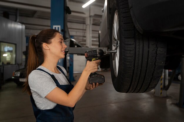 Meccanico femminile che lavora nel negozio su un'auto