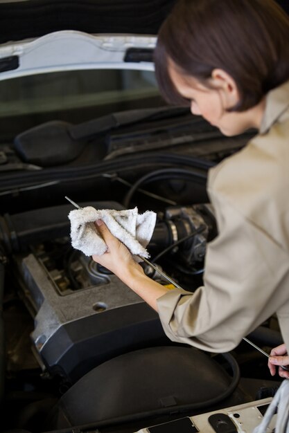 Meccanico femminile controllare il livello dell&#39;olio nel motore di un&#39;auto