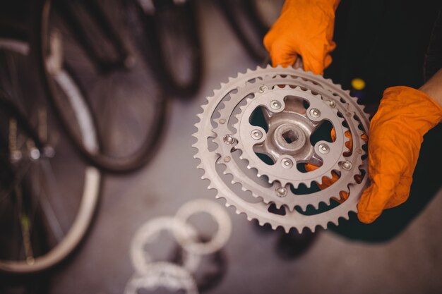 Meccanico in possesso di un ingranaggio della bicicletta