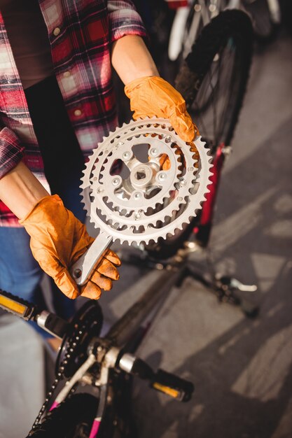 Meccanico in possesso di un ingranaggio della bicicletta