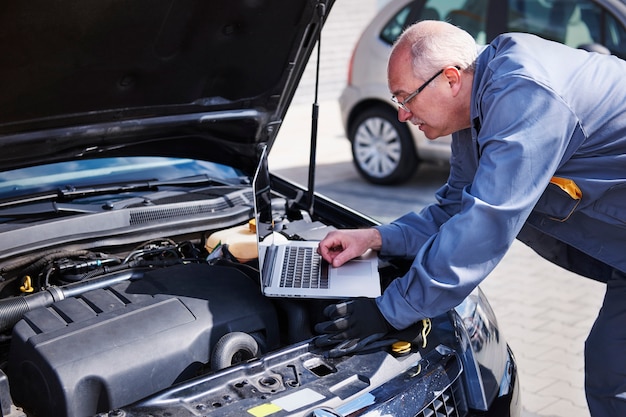 Meccanico professionista che utilizza la tecnologia contemporanea al lavoro