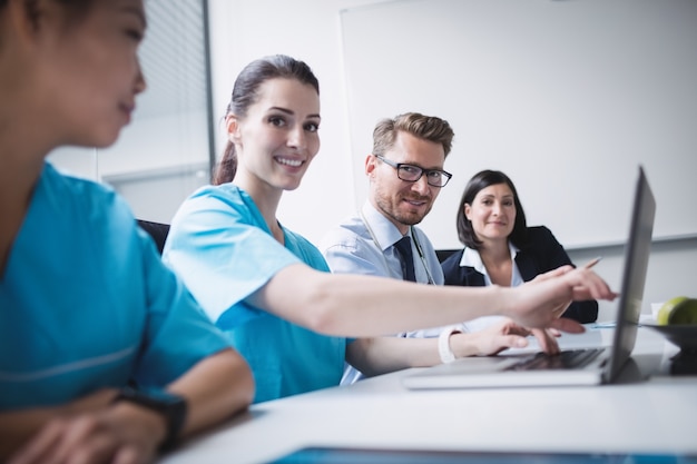 Medici che discutono su laptop in riunione