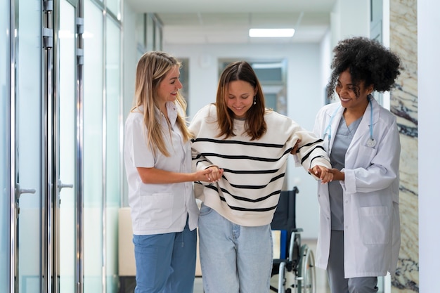 Medici femminili di vista frontale che aiutano il paziente