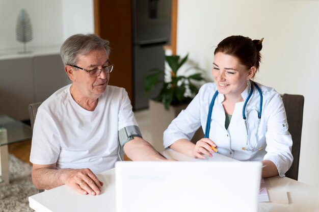 Medico a colpo medio che controlla paziente