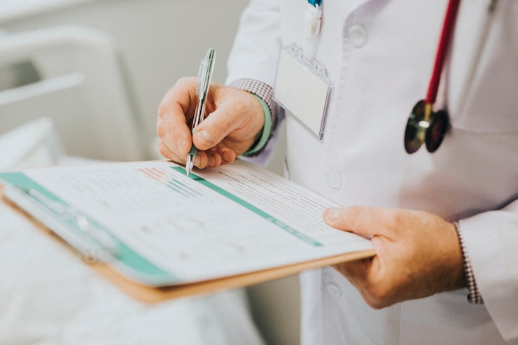 Foto gratuito medico annotando i sintomi di un paziente
