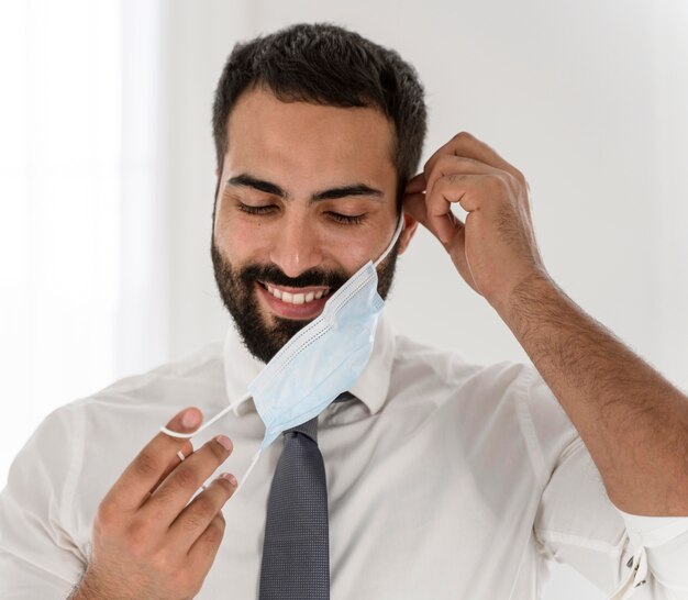 Medico barbuto che toglie la sua maschera medica