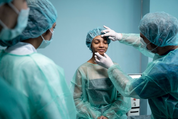 Medico che controlla il paziente sorridente prima dell'intervento chirurgico