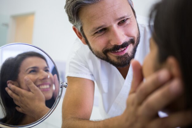 Medico che controlla la pelle dei pazienti dopo il trattamento cosmetico