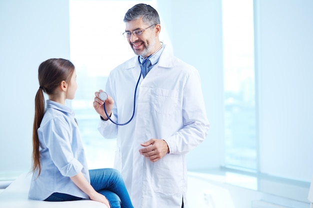 Medico che esamina la sua giovane paziente