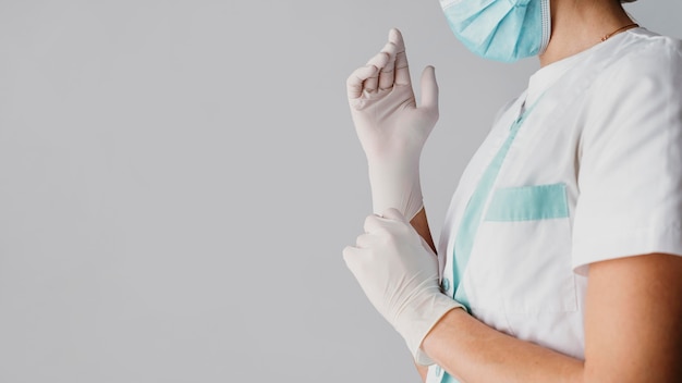 Medico che indossa guanti chirurgici con copia spazio