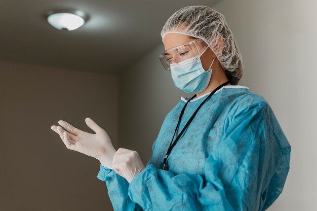 Medico che indossa i guanti chirurgici