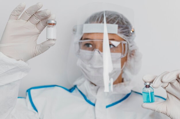 Medico che tiene una bottiglia di vaccino