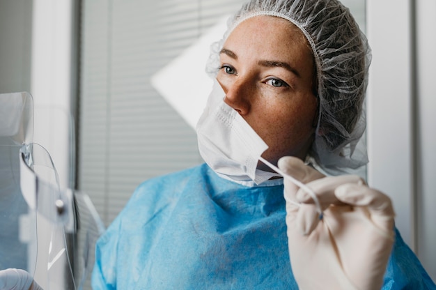 Medico che toglie la sua maschera facciale