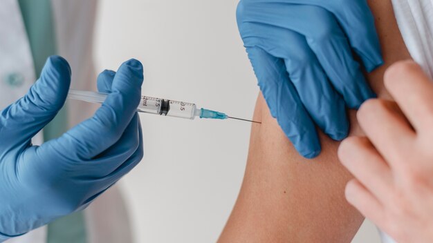 Medico con guanti che vaccinano il paziente