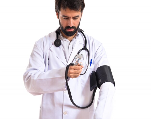 Medico con monitor di pressione sanguigna su sfondo bianco