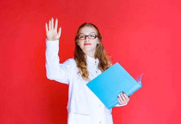 Medico con una cartella blu che saluta il suo paziente.