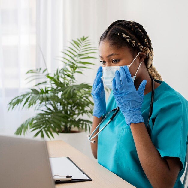Medico del colpo medio che indossa guanti e maschera