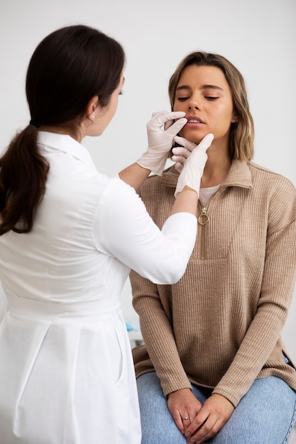 Medico del tiro medio che controlla il paziente