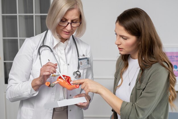 Medico del tiro medio che parla con una donna