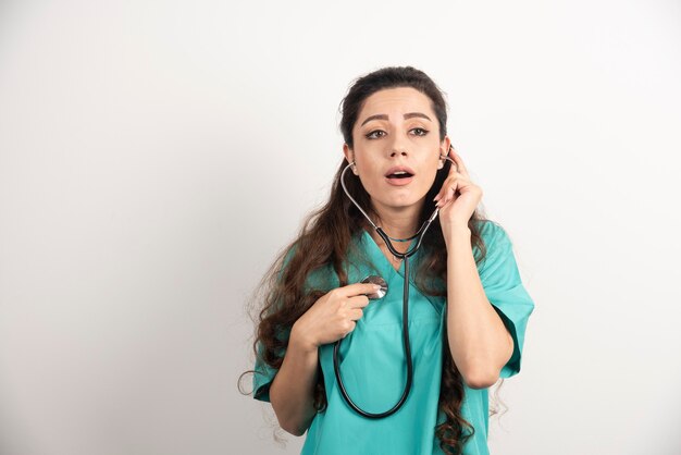 Medico della giovane donna in uniforme con lo stetoscopio.