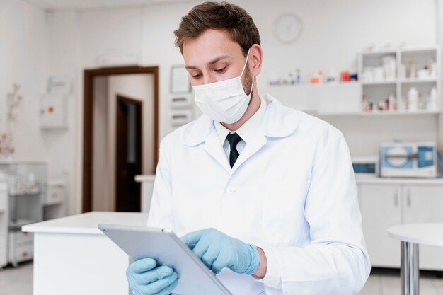 Medico di tiro medio con maschera e tablet