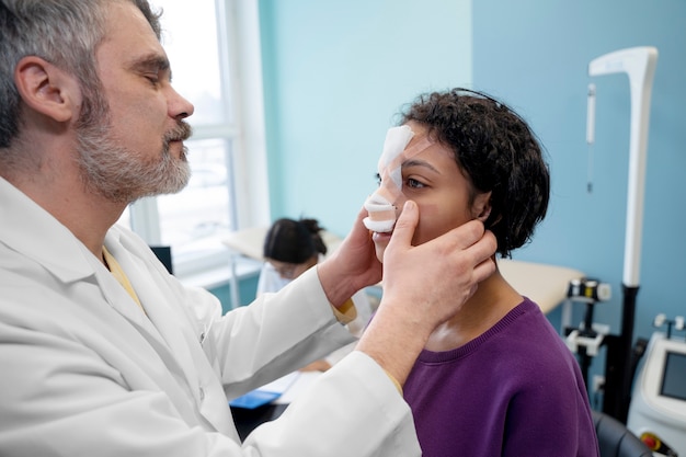 Medico di vista laterale che controlla il paziente post op