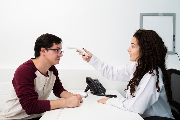Medico di vista laterale che controlla paziente
