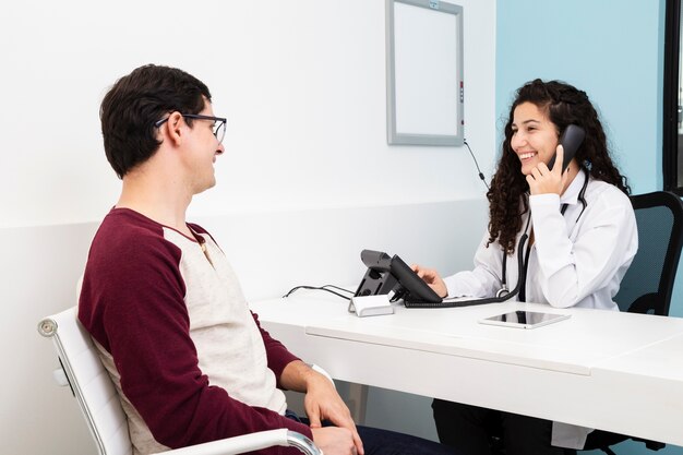 Medico di vista laterale parlando al telefono