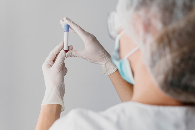 Foto gratuito medico di vista posteriore che tiene un campione di sangue