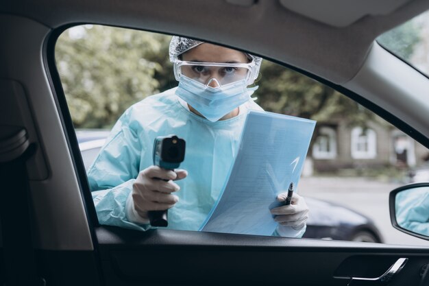 Medico donna usa la pistola termometro a infrarossi per controllare la temperatura corporea