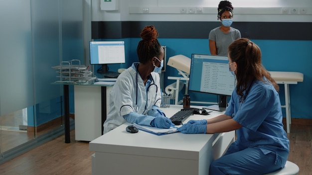 Medico e infermiere che lavorano con il documento di prescrizione per il controllo del paziente e l'assistenza sanitaria. Scrittura medica su carta medica per la consultazione e il trattamento per curare la donna con malattia in gabinetto.