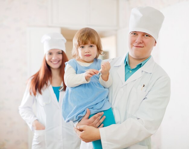 Medico e infermiere con bambino in clinica