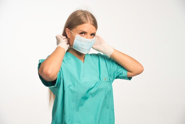 Medico femminile biondo che indossa la maschera per il viso.