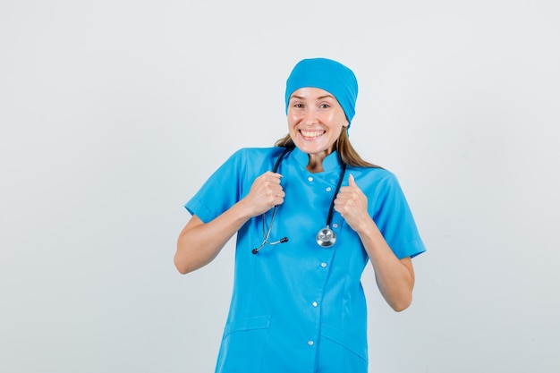 Medico femminile che celebra la vittoria in uniforme blu e che sembra felice