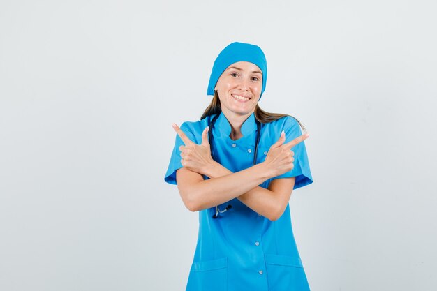 Medico femminile che indica via con il gesto della pistola in uniforme blu e che sembra allegro