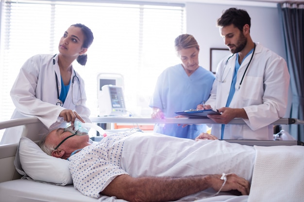 Medico femminile che mette la maschera di ossigeno sul fronte paziente