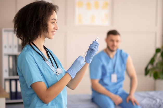 Medico femminile che prepara la vaccinazione per il suo collega