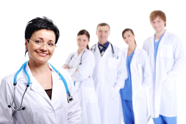 Medico femminile che ride felice in primo piano e altri medici