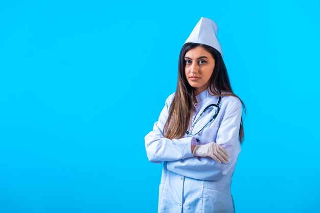 Medico femminile con lo stetoscopio che propone come professionista.