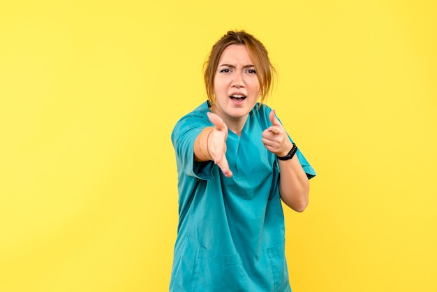 Medico femminile di vista frontale che agita le mani sullo spazio giallo