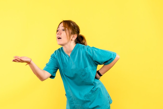 Medico femminile di vista frontale che discute con qualcuno sullo spazio giallo