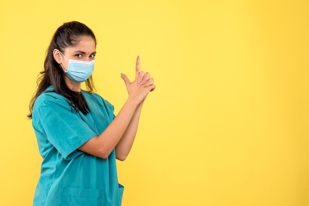 Medico femminile di vista frontale che fa la condizione della pistola del dito