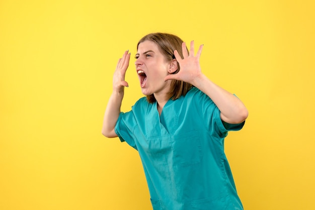 Medico femminile di vista frontale che grida sullo spazio giallo